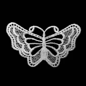 Macro view of white water-soluble lace butterfly embroidery patch with hollow details