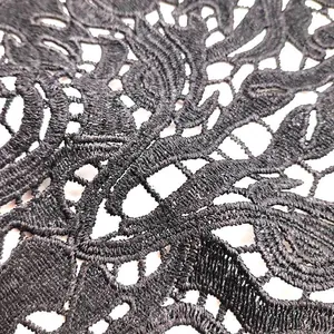 Close-up of black water-soluble lace embroidery with intricate floral hollow pattern