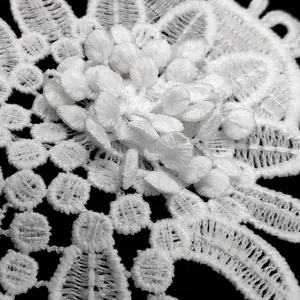 Macro detail of a white 3D water-soluble lace flower patch with multi-layered embroidery