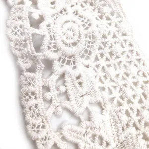 Close-up of intricate white cotton water-soluble lace embroidery collar detail.