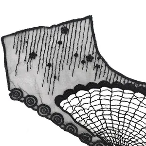 Macro view of black fan-shaped lace embroidery collar with intricate mesh detailing