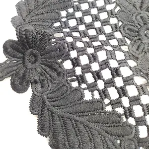 Detailed close-up view of black water-soluble lace flower with hollow embroidery