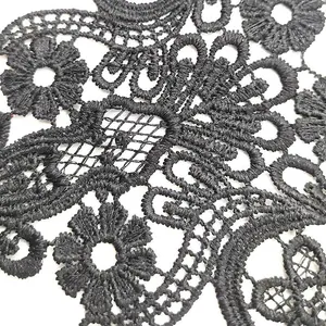 Detailed macro view of black water-soluble lace fabric with intricate floral embroidery
