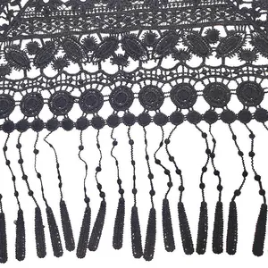 Close-up of black water soluble lace trim with delicate embroidery and tassel detail