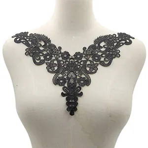 Detailed macro view of black water-soluble floral lace embroidery applique on dress form