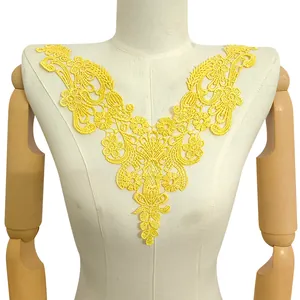 Detailed view of elegant yellow hollow embroidered water-soluble lace neckline applique.