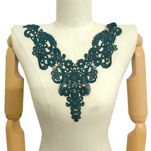 Detailed view of an elegant teal water-soluble lace neckline appliqué on a white mannequin