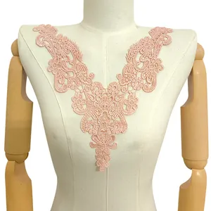 Detail view of a peach water-soluble lace floral embroidery collar applique on a mannequin