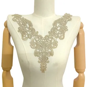 Detailed macro view of gold water-soluble embroidered lace neckline applique on mannequin