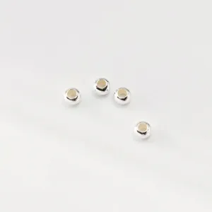 Close-up macro view of four small 925 silver plated flat spacer beads