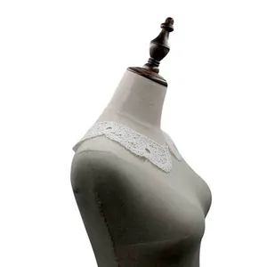 Detailed view of white water-soluble lace collar with 3D hollow embroidery on mannequin