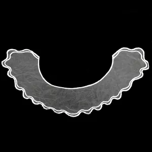 Detailed macro view of white organza embroidered collar with delicate scalloped edges