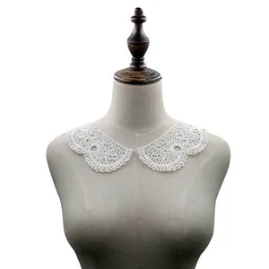 Detailed view of intricate white water-soluble lace collar on a mannequin torso