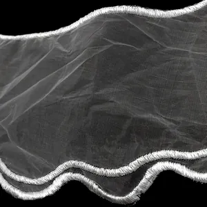 Close-up of white organza embroidery collar with delicate wavy lace edge detail.