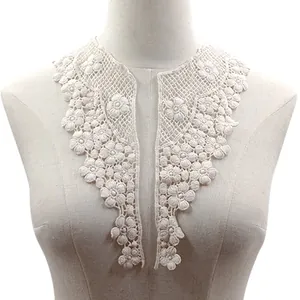 Detailed view of white floral water-soluble lace collar patches on a display mannequin.