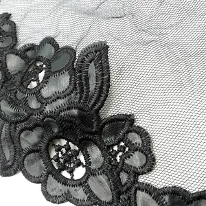 Primer plano del bordado floral de cuero sintético negro en un cuello de encaje de malla