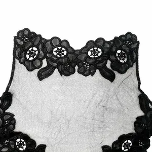 Primer plano detallado de un cuello falso de encaje negro con bordado floral.