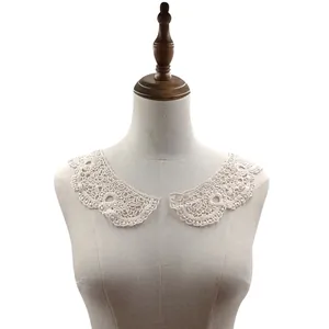 Macro detail of white hollow lace collar embroidery accessory on mannequin torso