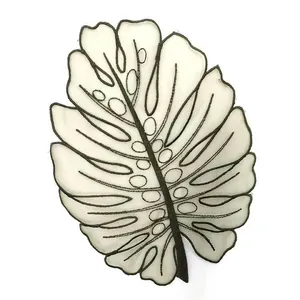 Dettaglio della toppa ricamata in organza a forma di foglia di monstera ricca di dettagli