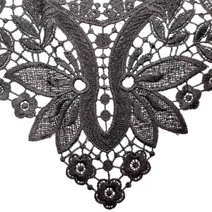Macro view showing intricate embroidery detail on a black water-soluble lace collar