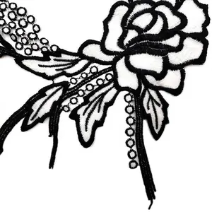 Macro detail of black and white rose lace embroidery patch with intricate hollow design