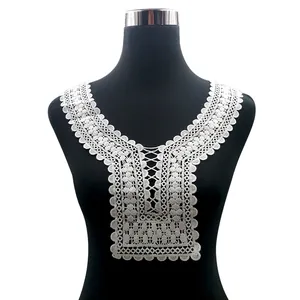 Detailed view of a white water-soluble lace neckline applique on a black mannequin