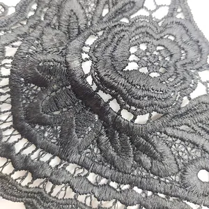 Close-up of black water-soluble lace with 3D hollowed-out floral embroidery details