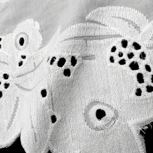 Detailed macro view showing the fine texture of white cotton eyelet embroidery lace