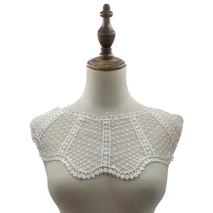 Detailed close-up of white water-soluble lace false collar with intricate embroidery