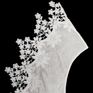 Detailed macro view of white water-soluble floral embroidery lace on cotton fabric base