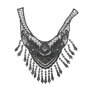 Close-up detail of black water-soluble lace collar with 3D floral embroidery and fringe