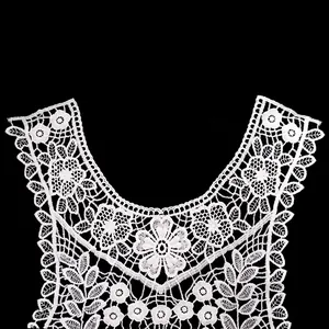 Detailed view of intricate white floral lace collar embroidery on black background