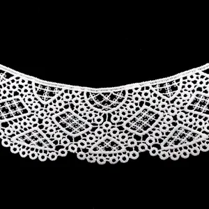 Vista detallada de cuello de encaje blanco con intrincados bordados artesanales.