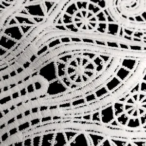 Primer plano del intrincado bordado de encaje blanco hidrosoluble sobre un fondo negro