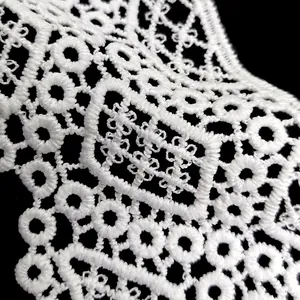 Detalle en primer plano de bordado de encaje blanco soluble en agua con motivos geométricos