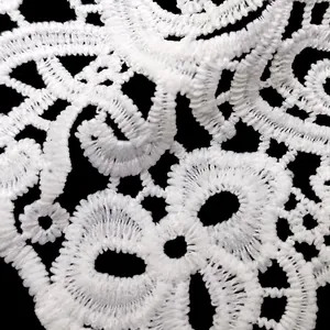 Macro detail of white water-soluble milk silk lace with intricate floral embroidery