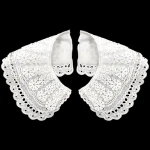 Detalle en primer plano del cuello falso de encaje blanco con bordado floral fino