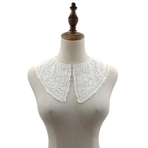 Detail view of a white cotton embroidered detachable collar with elegant eyelet lace.