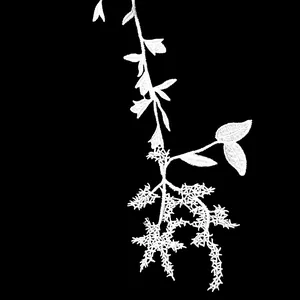 Detailed close-up view of white water-soluble lace embroidery flower for DIY wedding dress