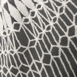 Close-up macro view of white milk silk water-soluble lace embroidery with mesh base