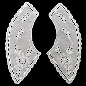 Detailed view of white cotton embroidered eyelet lace with floral patterns.