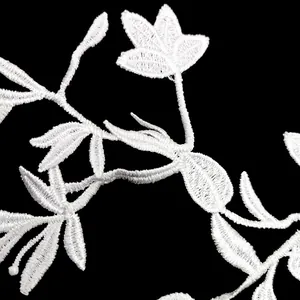 Close-up detail of white water-soluble lace flower embroidery with intricate stitching.