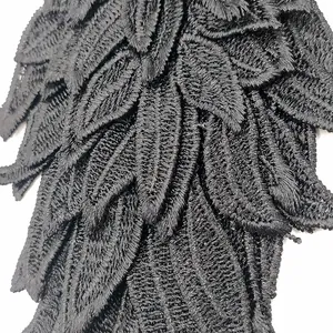 Close-up view of black embroidered angel wing lace patch with intricate texture details