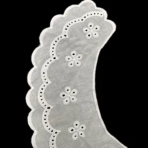 Primer plano de cuello bordado de algodón blanco con flores caladas y bordes festoneados