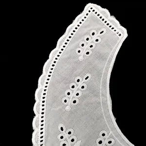 Close-up of white cotton embroidered faux collar with detailed eyelet design