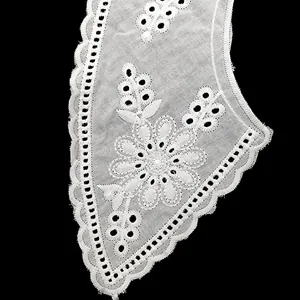 Close-up of white cotton embroidered lace collar with elegant floral eyelet details
