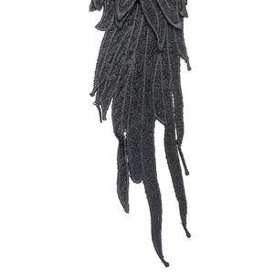 Macro detail of black embroidered water-soluble lace angel wing applique patch