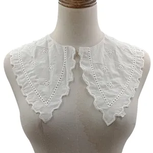 Close-up detail of white cotton embroidered fake collar with floral eyelet lace pattern
