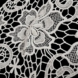 Macro detail of white water-soluble milk silk lace with intricate floral embroidery
