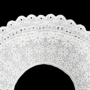Primer plano macro del intrincado bordado y textura calada del cuello de encaje blanco